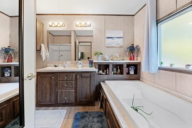 a bathroom with a tub sink and mirror