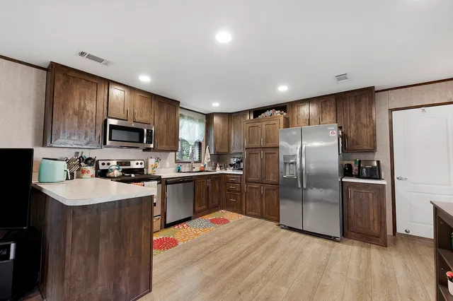 a kitchen with granite countertop a refrigerator stove top oven a sink and dishwasher