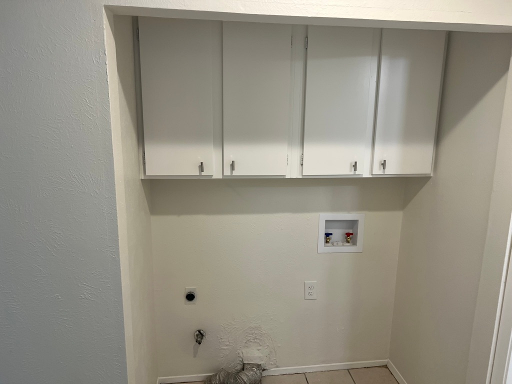 5302 Indio Circle, Unit A Austin, TX 78745 - Photo 9 of 13 Laundry room with a textured wall, cabinet space, hookup for a washing machine, hookup for an electric dryer, and light tile patterned floors