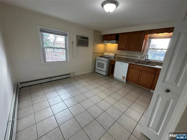 a kitchen with granite countertop a sink cabinets and stainless steel appliances