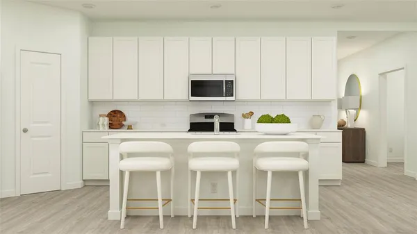 a white kitchen with a stove a sink and white cabinets