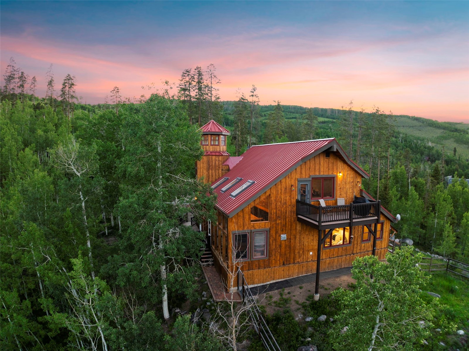 1516 Blue Ridge Road Silverthorne, CO 80498 - Photo 5 of 50 Back of house at dusk with a metal roof, a wooded view, and a standing seam roof