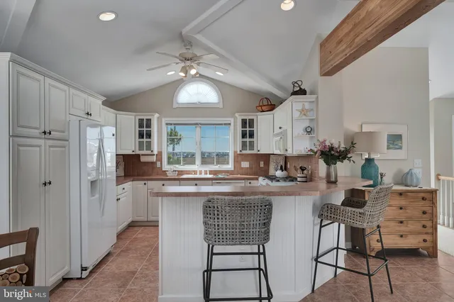 a kitchen with stainless steel appliances kitchen island granite countertop a dining table chairs and granite counter tops