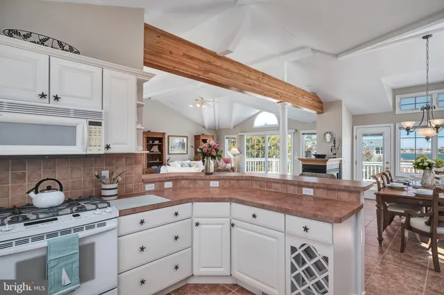 a kitchen with granite countertop a sink a stove and cabinets