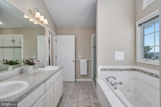 a spacious bathroom with a granite countertop tub sink and mirror
