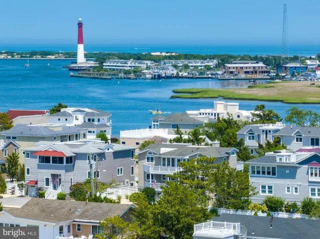 an aerial view of residential houses with outdoor space and lake view