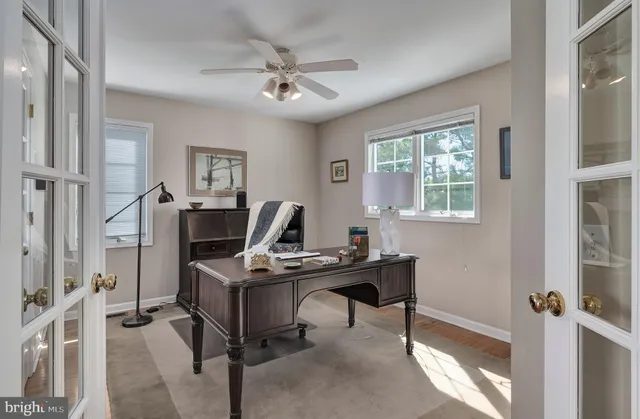 a view of a workspace with furniture and a window