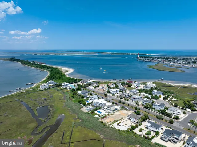 an aerial view of ocean and residential houses with outdoor space