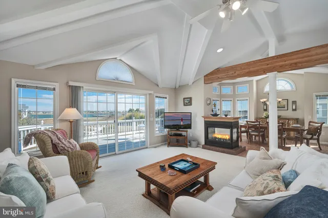 a living room with furniture fireplace and a large window