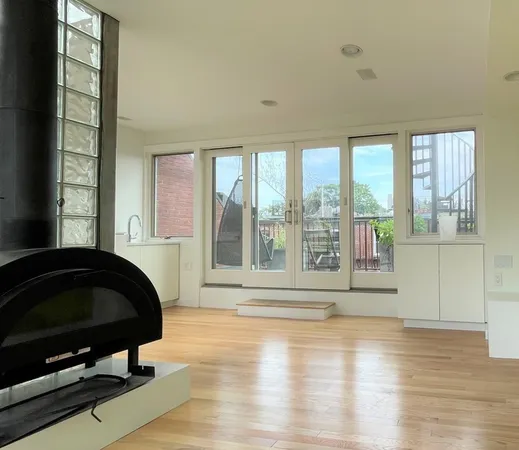 a view of a room with a large window and wooden floor