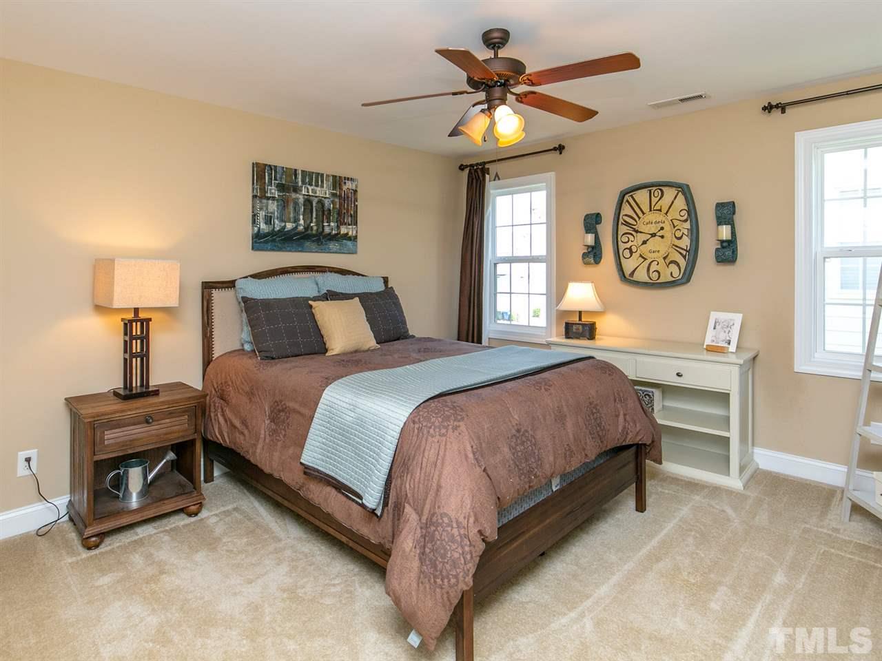 1348 Ileagnes Road Raleigh, NC 27603 - Photo 19 of 25 a spacious bedroom with a bed a chandelier and a window