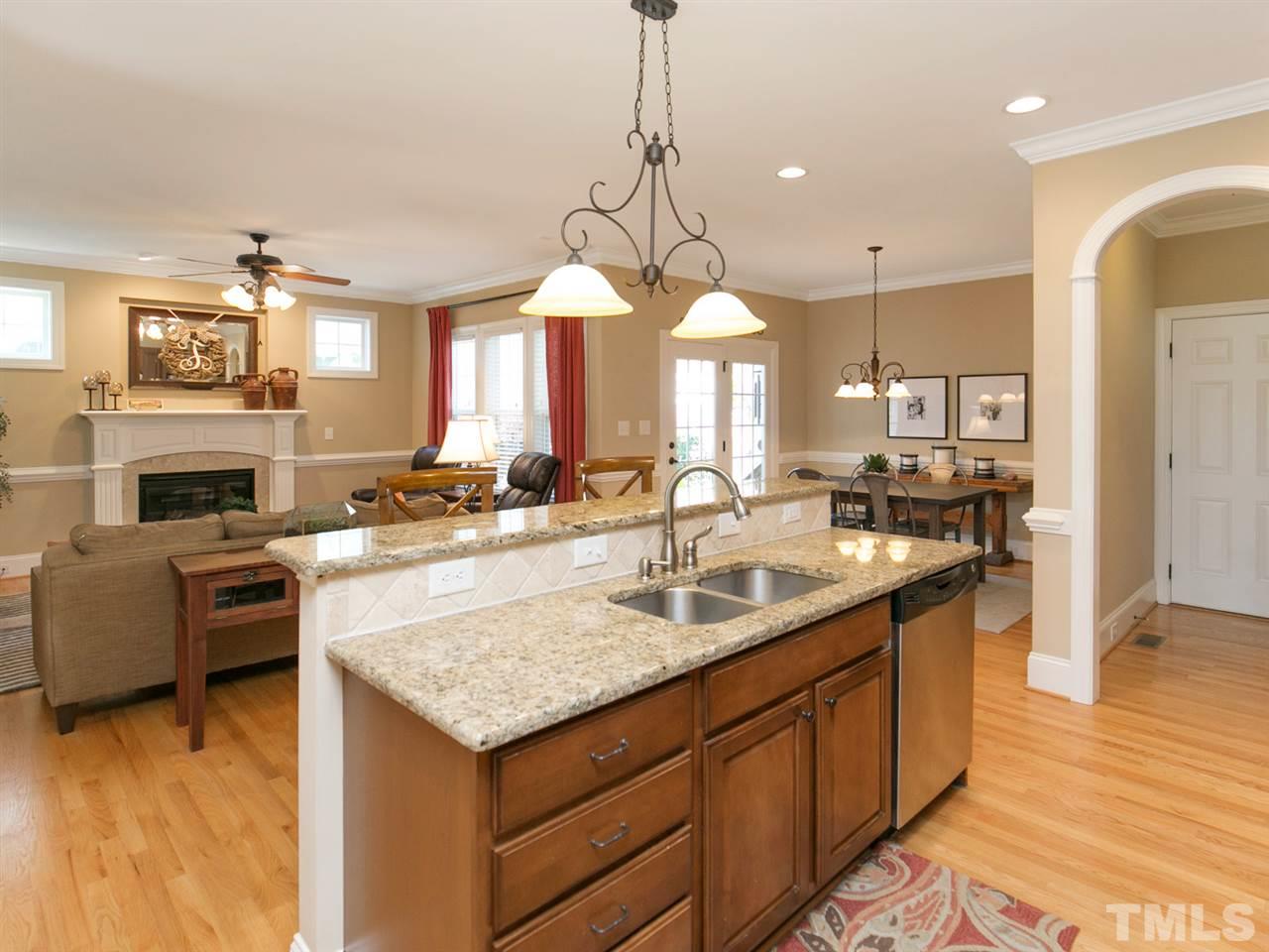 1348 Ileagnes Road Raleigh, NC 27603 - Photo 7 of 25 a kitchen with a stove a sink dishwasher a kitchen island with wooden cabinets and floor