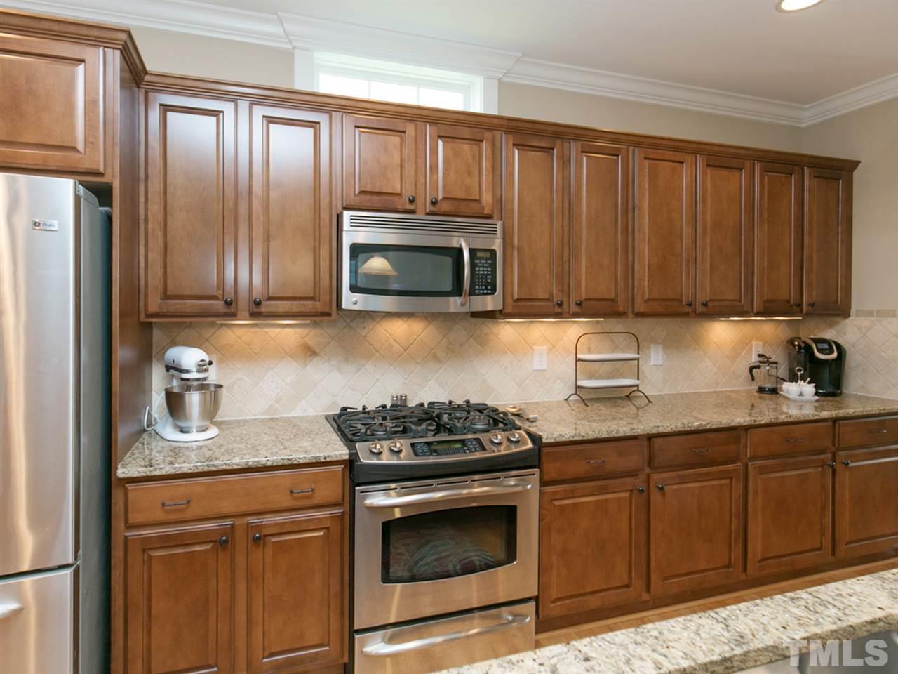 1348 Ileagnes Road Raleigh, NC 27603 - Photo 8 of 25 a kitchen with granite countertop stainless steel appliances a stove a sink and a microwave