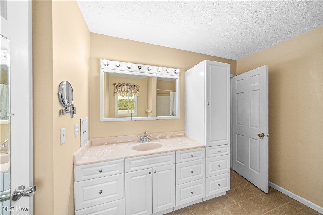 3325 Frantz Road Medina, OH 44256 - Photo 21 of 40 Full bathroom featuring a textured ceiling, baseboards, tile patterned flooring, and vanity