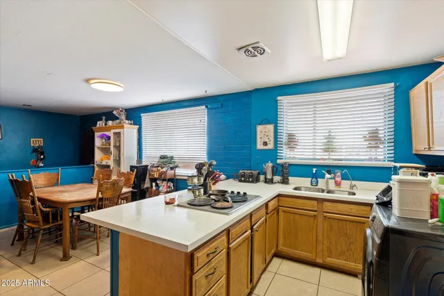 a kitchen with a sink a counter top space and living room view