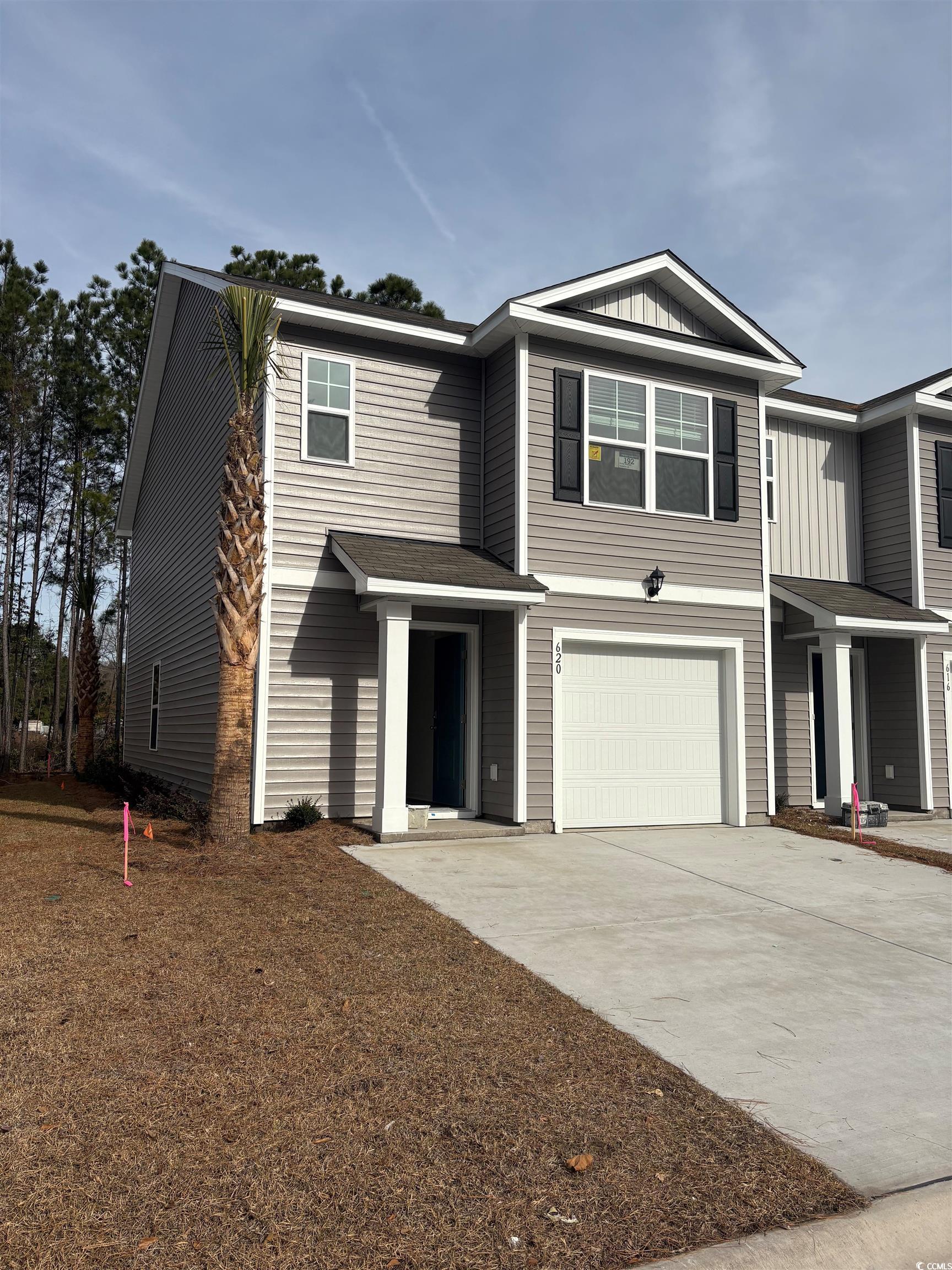 View of front of property featuring driveway, board and batten siding, and an attached garage