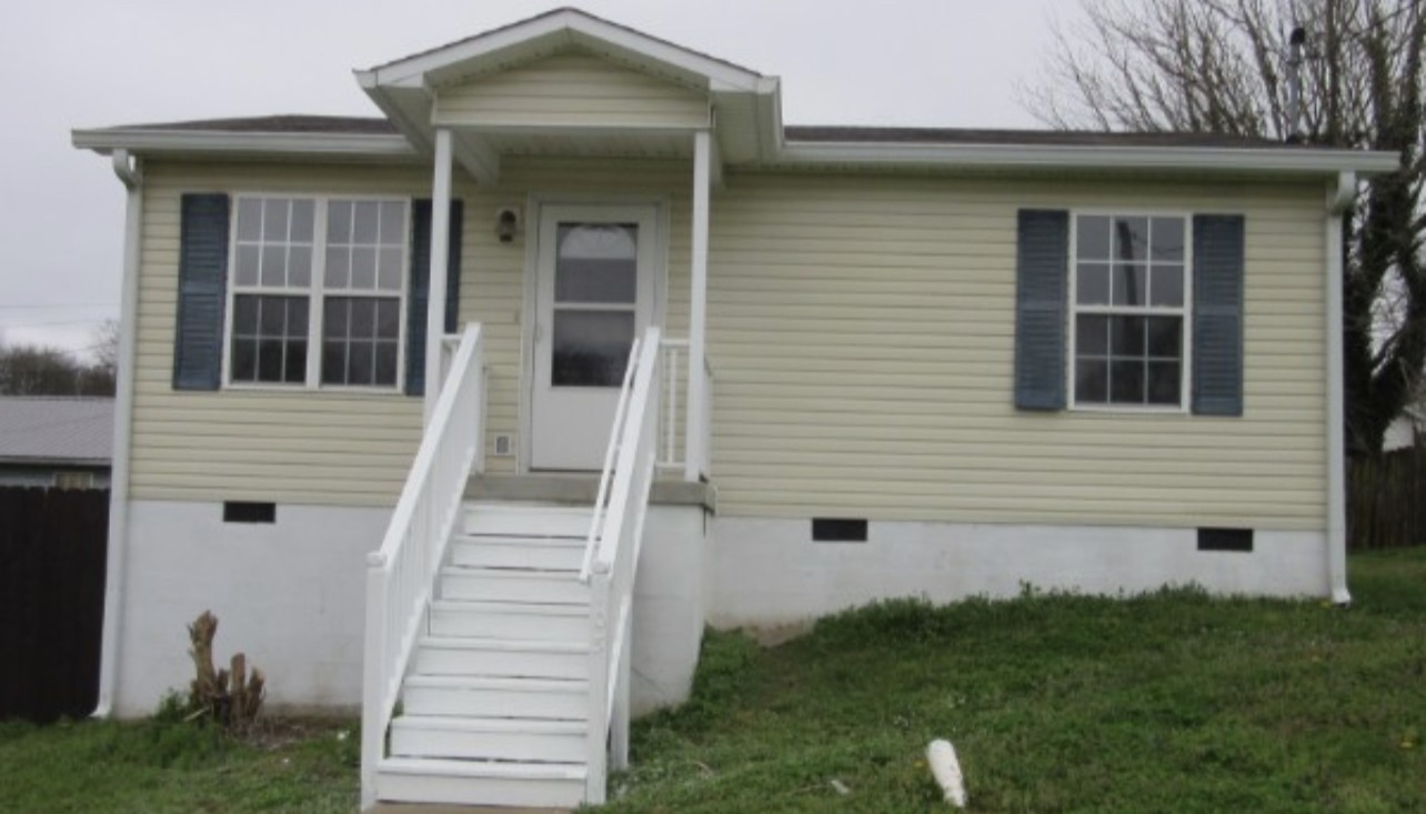a view of a house with brick walls and a small yard