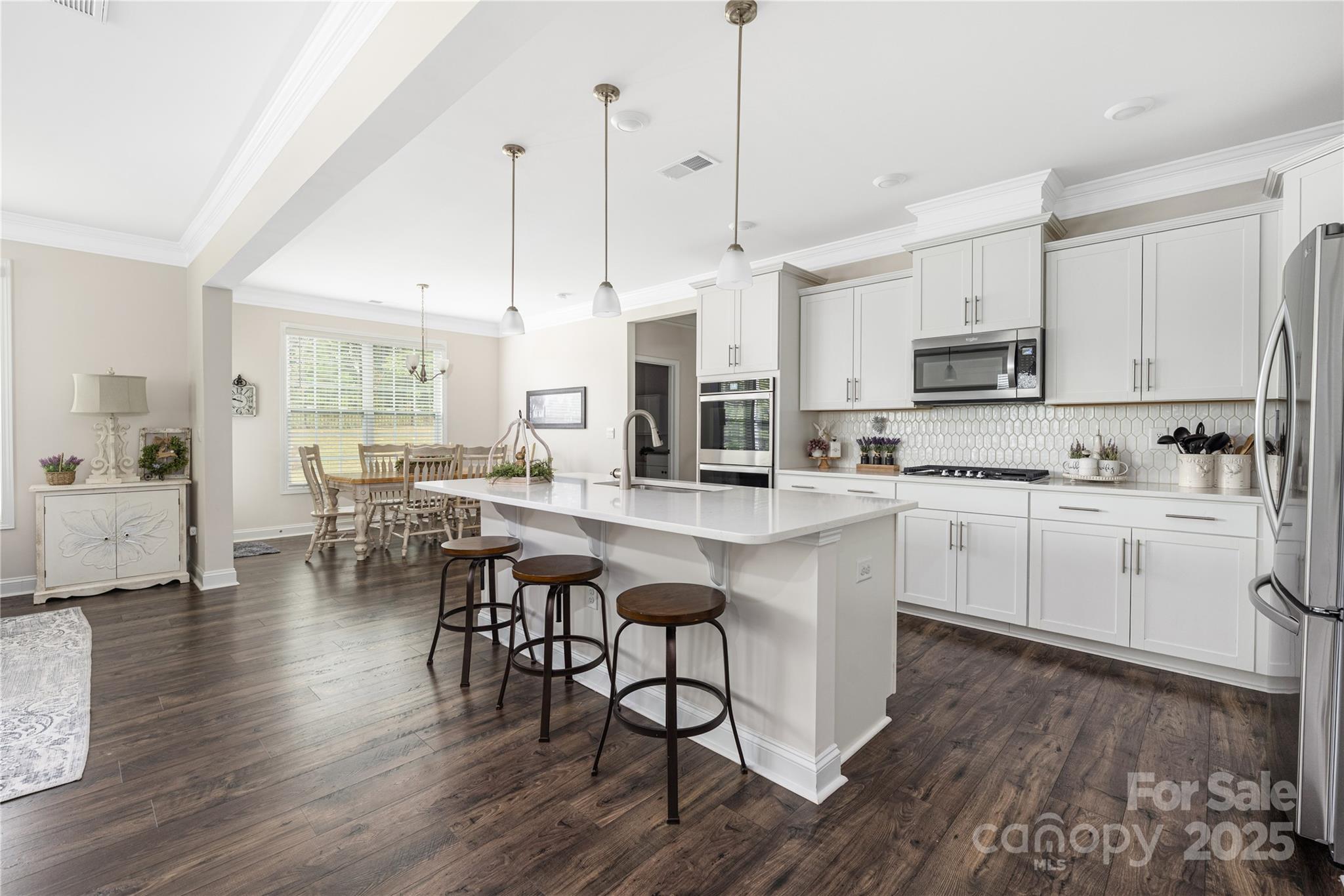 121 Rhuidean Court Troutman, NC 28166 - Photo 12 of 44 a kitchen with stainless steel appliances kitchen island granite countertop a stove a sink a center island and cabinets