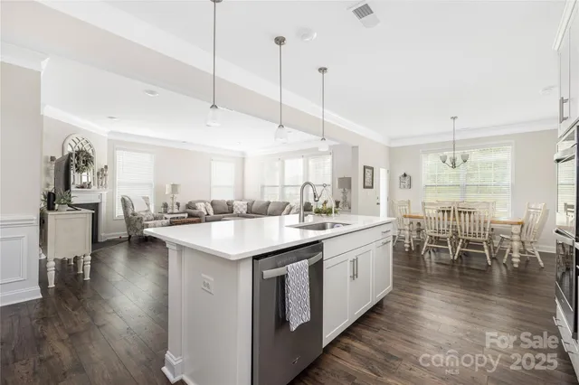 a kitchen with lots of counter space a sink appliances and dining table