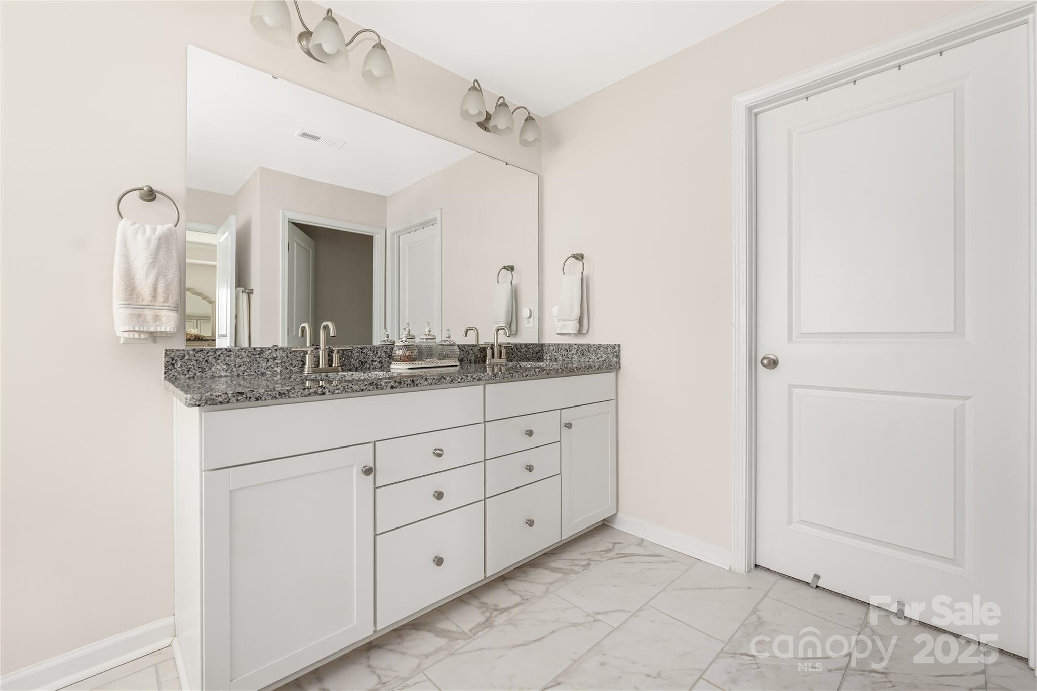 121 Rhuidean Court Troutman, NC 28166 - Photo 28 of 44 a bathroom with a granite countertop sink and a mirror