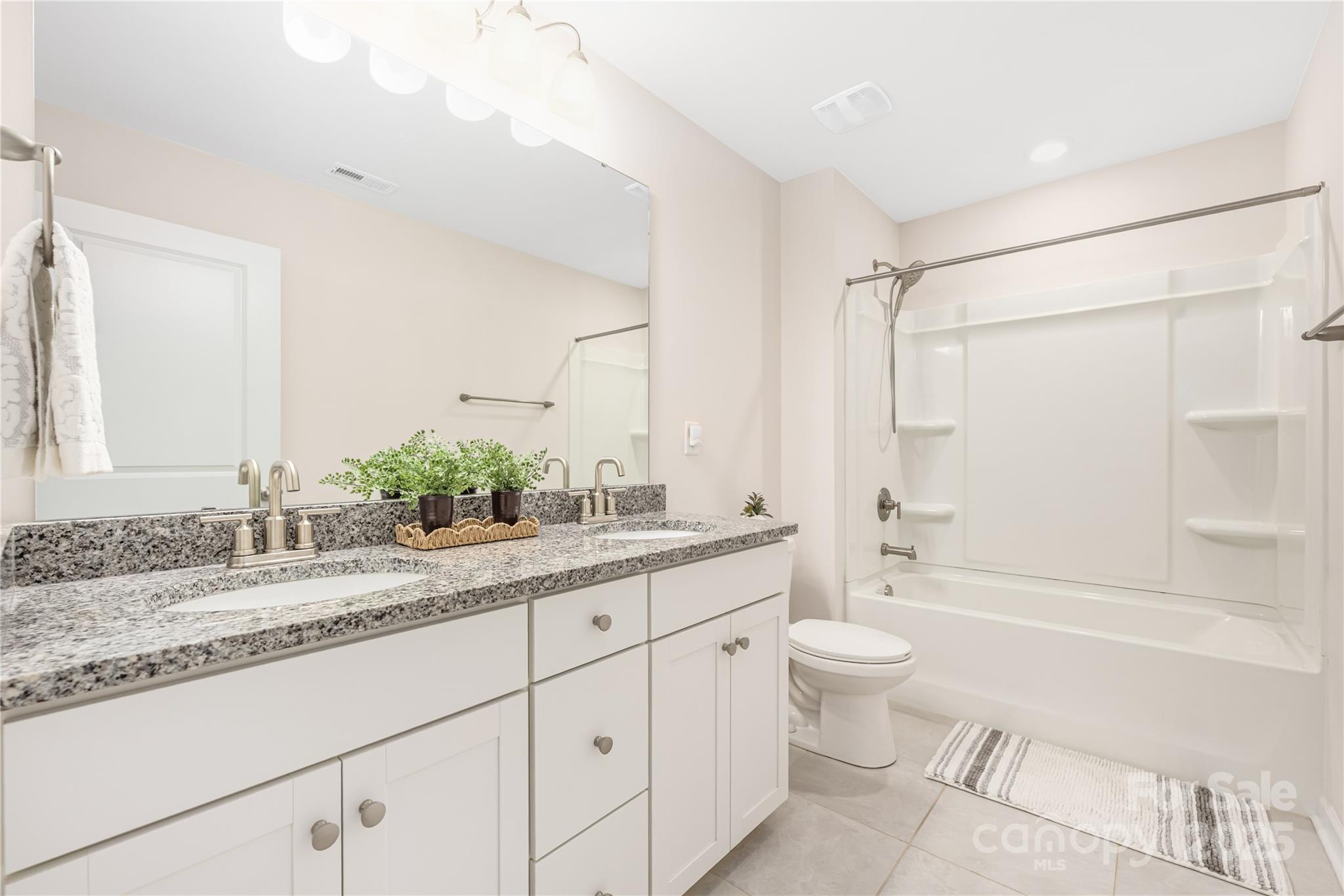 121 Rhuidean Court Troutman, NC 28166 - Photo 34 of 44 a bathroom with a granite countertop sink mirror vanity and toilet