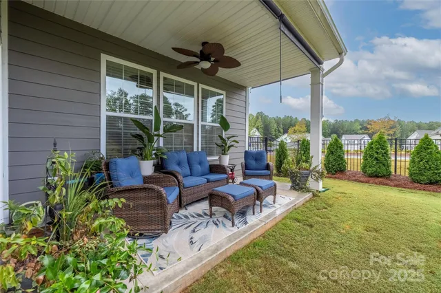 a view of a patio with couches table and chairs and potted plants