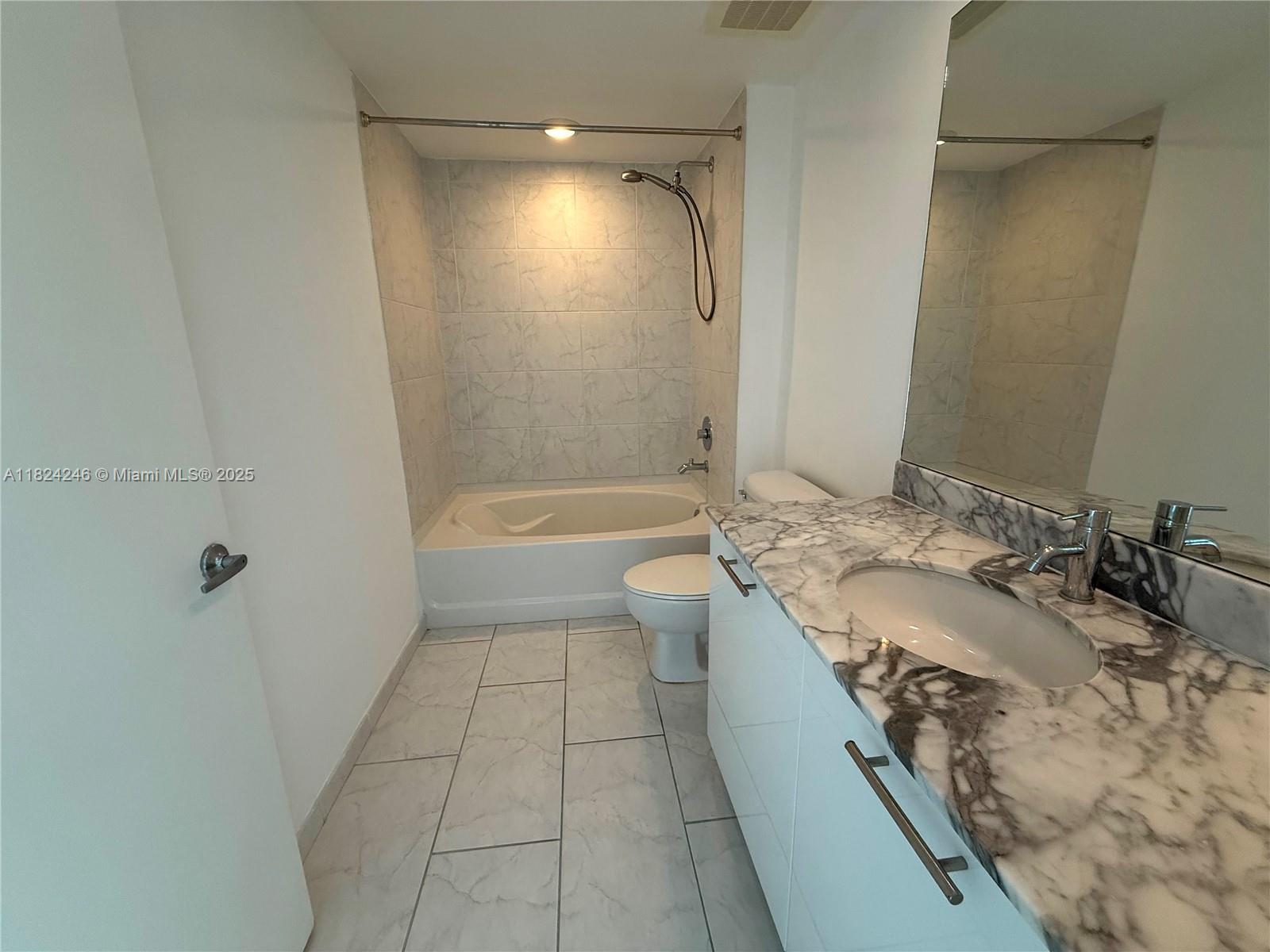 951 Brickell Avenue, Unit 3703 Miami, FL 33131 - Photo 12 of 34 a bathroom with a granite countertop sink a toilet and shower