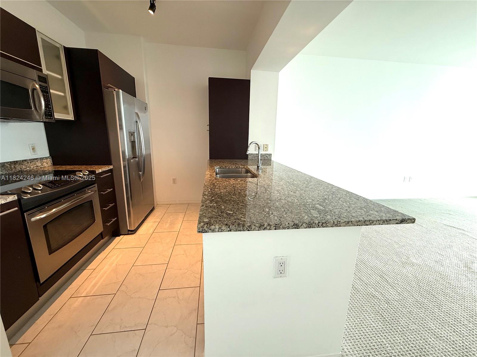 951 Brickell Avenue, Unit 3703 Miami, FL 33131 - Photo 2 of 34 a kitchen with stainless steel appliances granite countertop a sink and a stove