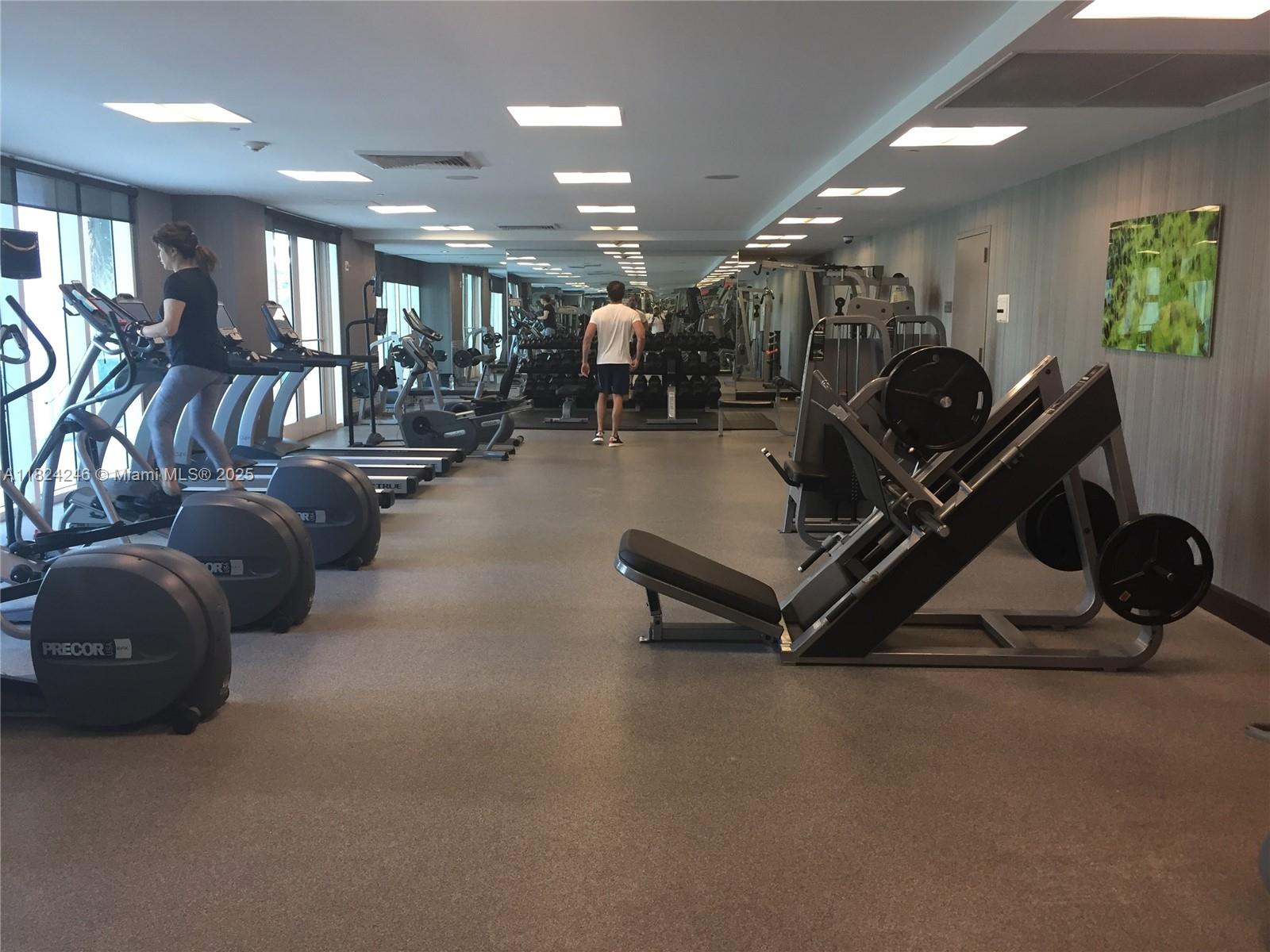 951 Brickell Avenue, Unit 3703 Miami, FL 33131 - Photo 23 of 34 a room with gym equipment and lots of mirrors