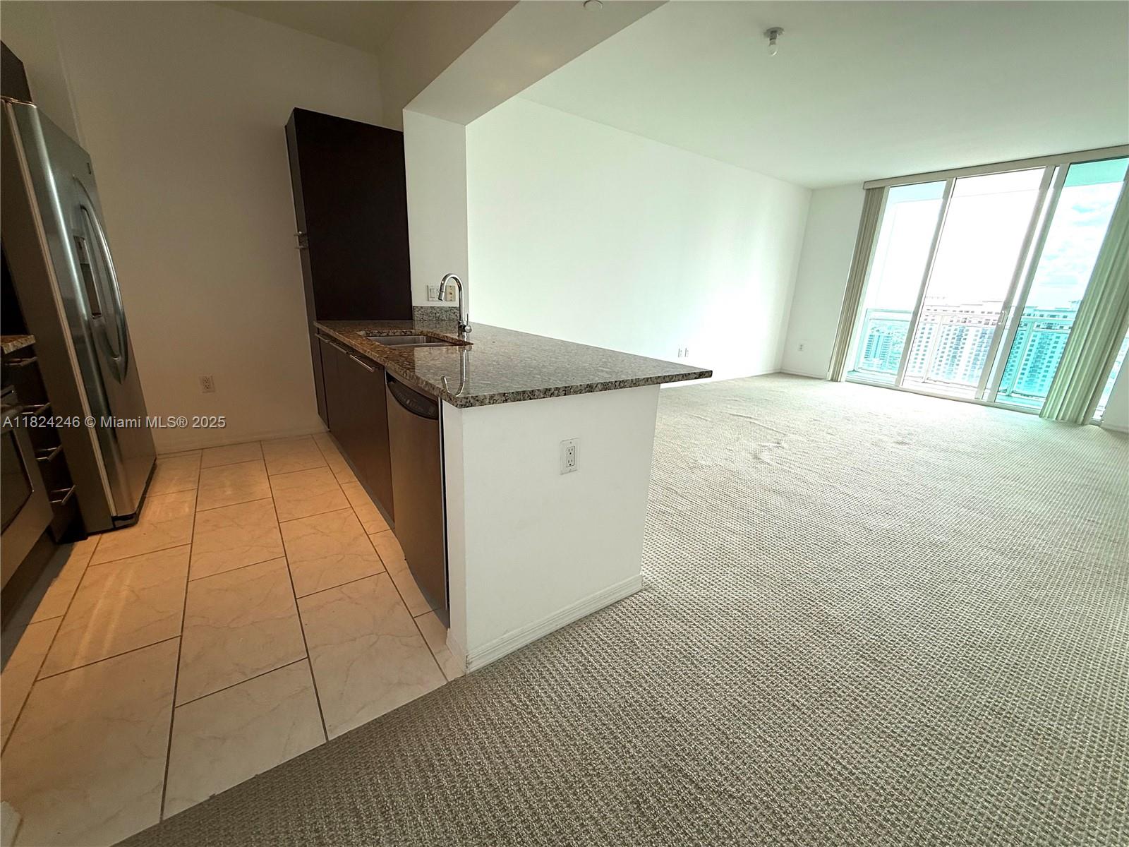951 Brickell Avenue, Unit 3703 Miami, FL 33131 - Photo 3 of 34 a kitchen with granite countertop a sink a stove and a refrigerator