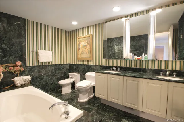 a bathroom with a sink a toilet a mirror and a large window