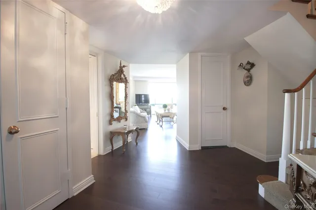 a view of a hallway view with wooden floor and a living room
