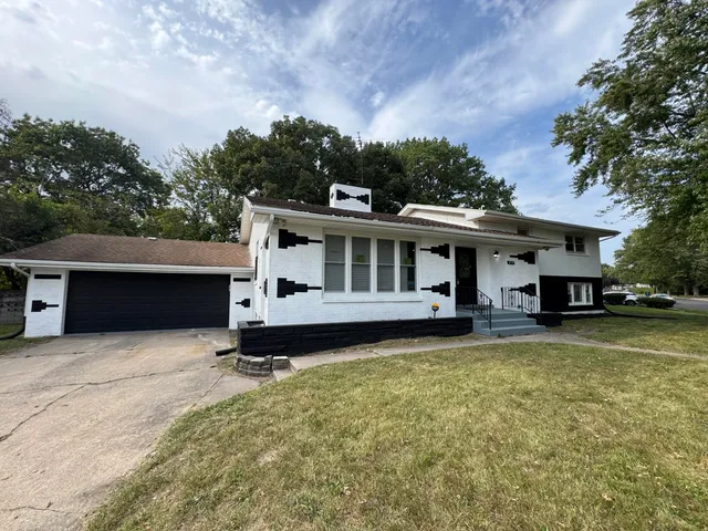 a view of a house with a yard and sitting area