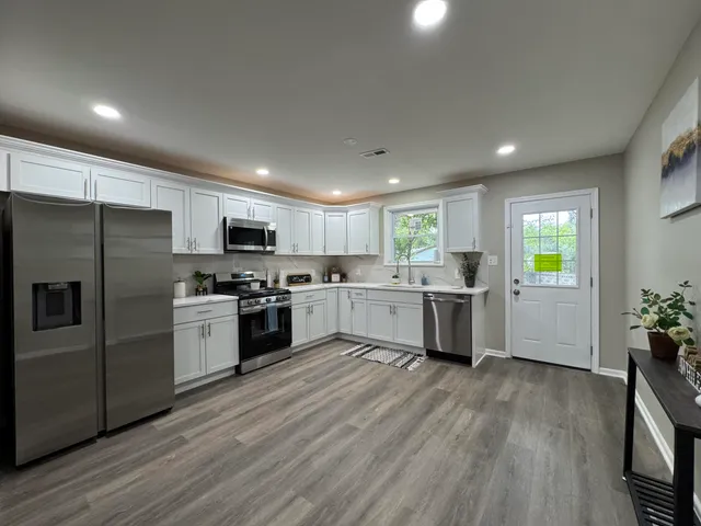 a kitchen with a refrigerator sink and cabinets