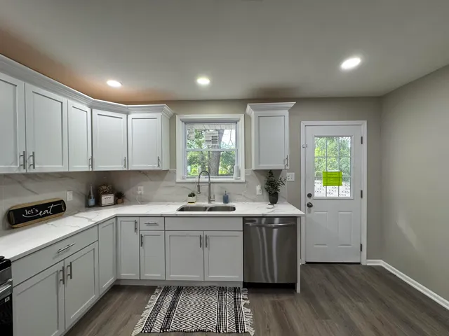a kitchen with a sink stove cabinets and wooden floor