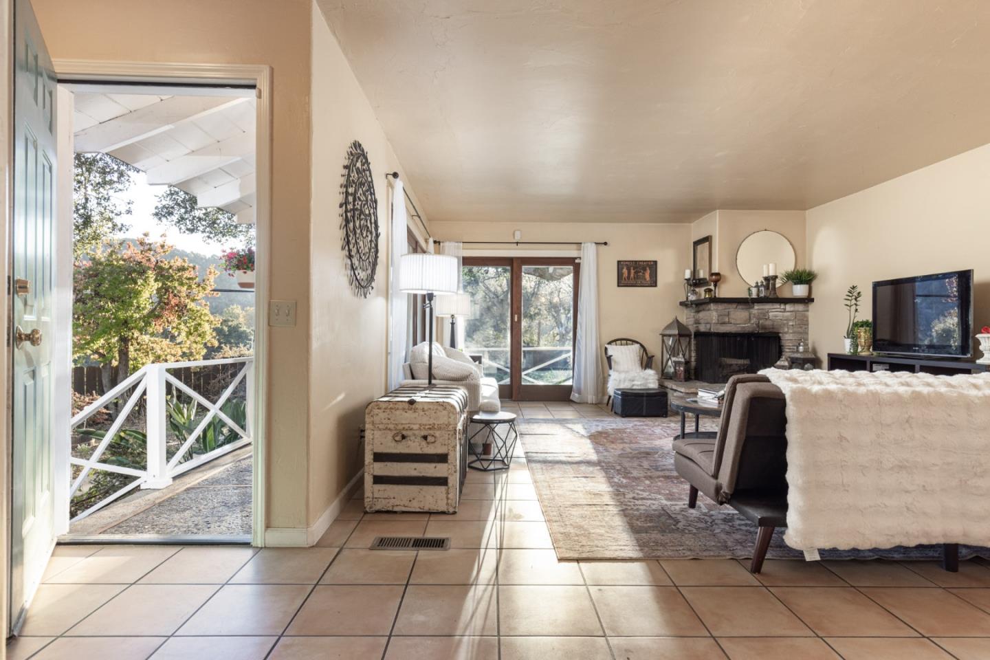 9805 Carmel Valley Road Carmel, CA 93923 - Photo 11 of 35 a living room with furniture a fireplace and a floor to ceiling window