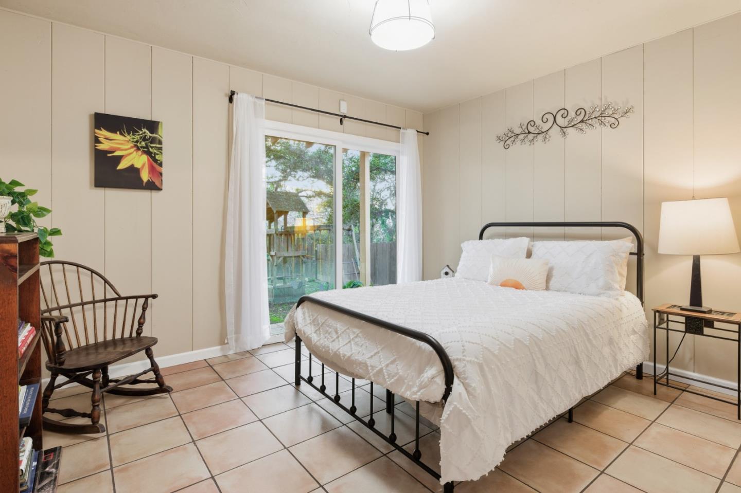 9805 Carmel Valley Road Carmel, CA 93923 - Photo 19 of 35 a bedroom with a bed a painting on the wall and a window