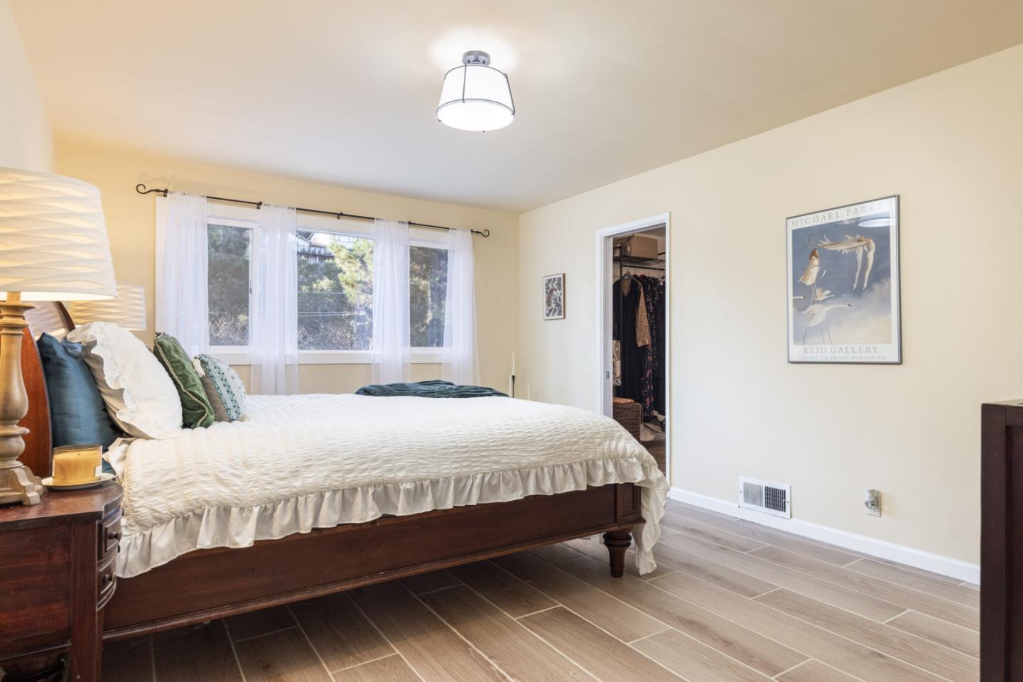 9805 Carmel Valley Road Carmel, CA 93923 - Photo 22 of 35 a bedroom with a large bed and a chandelier
