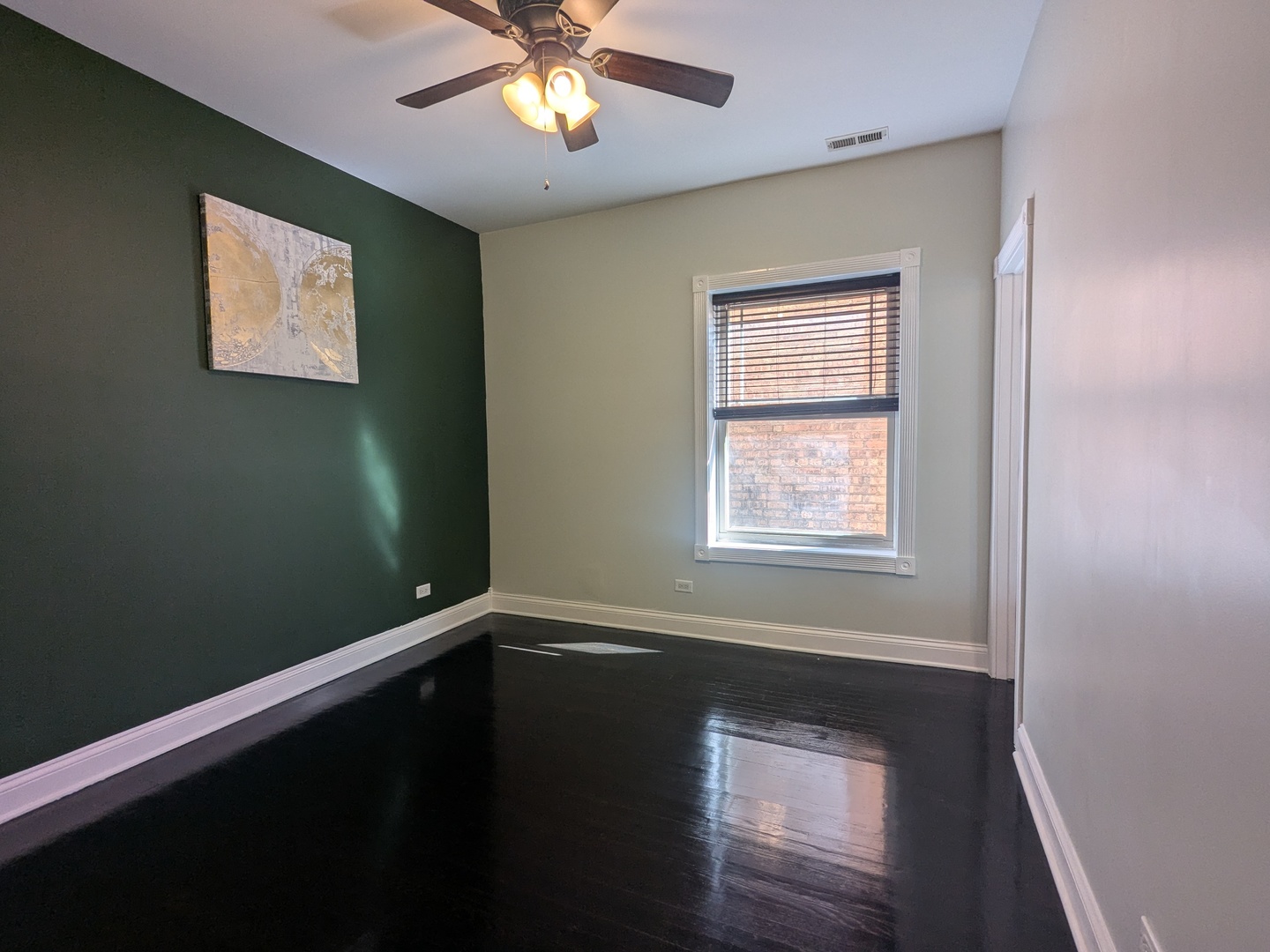 6814 North Ashland Boulevard, Unit 1C Chicago, IL 60626 - Photo 12 of 31 a view of an empty room with a window and wooden floor