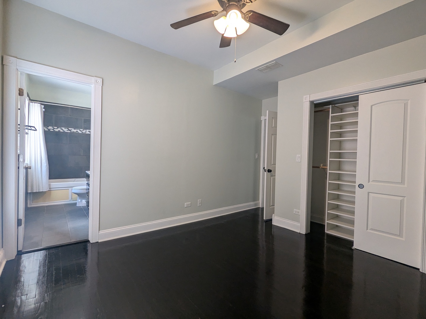 6814 North Ashland Boulevard, Unit 1C Chicago, IL 60626 - Photo 13 of 31 an empty room with wooden floor chandelier fan and windows