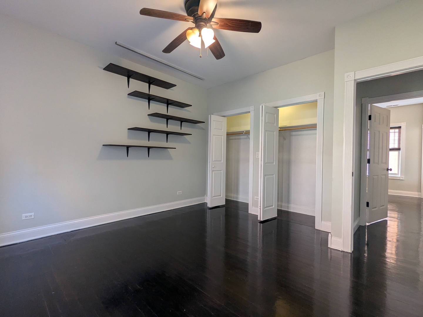 6814 North Ashland Boulevard, Unit 1C Chicago, IL 60626 - Photo 16 of 31 an empty room with wooden floor chandelier fan and windows