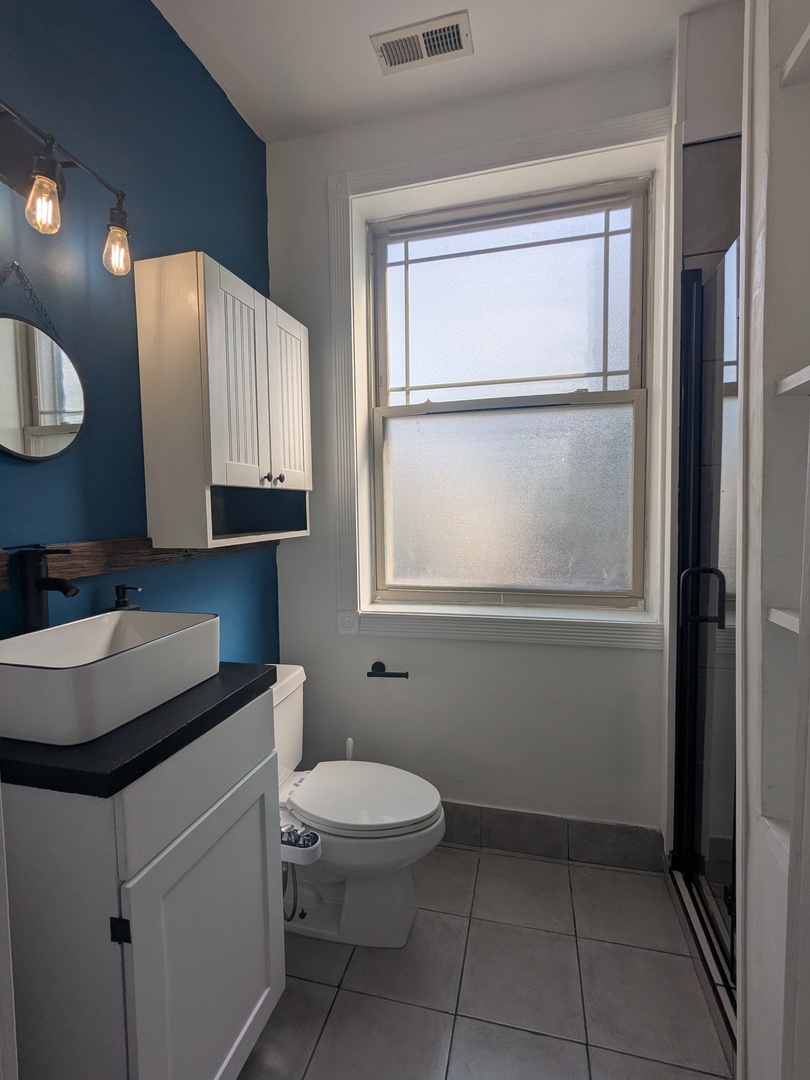 6814 North Ashland Boulevard, Unit 1C Chicago, IL 60626 - Photo 17 of 31 a bathroom with a toilet sink vanity and mirror