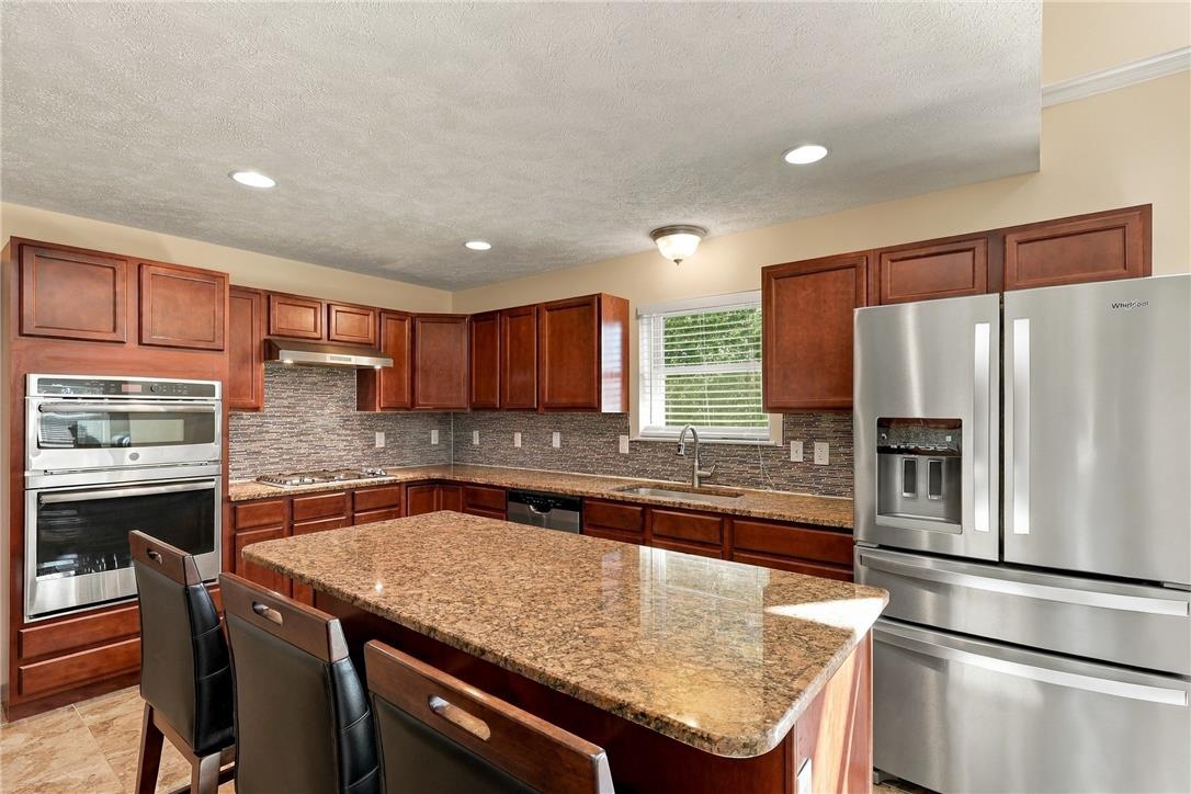 1657 Rachel Road Stroudsburg, PA 18360 - Photo 14 of 46 Polished stone countertops and rich wooden cabinetry anchor this functional cooking space.