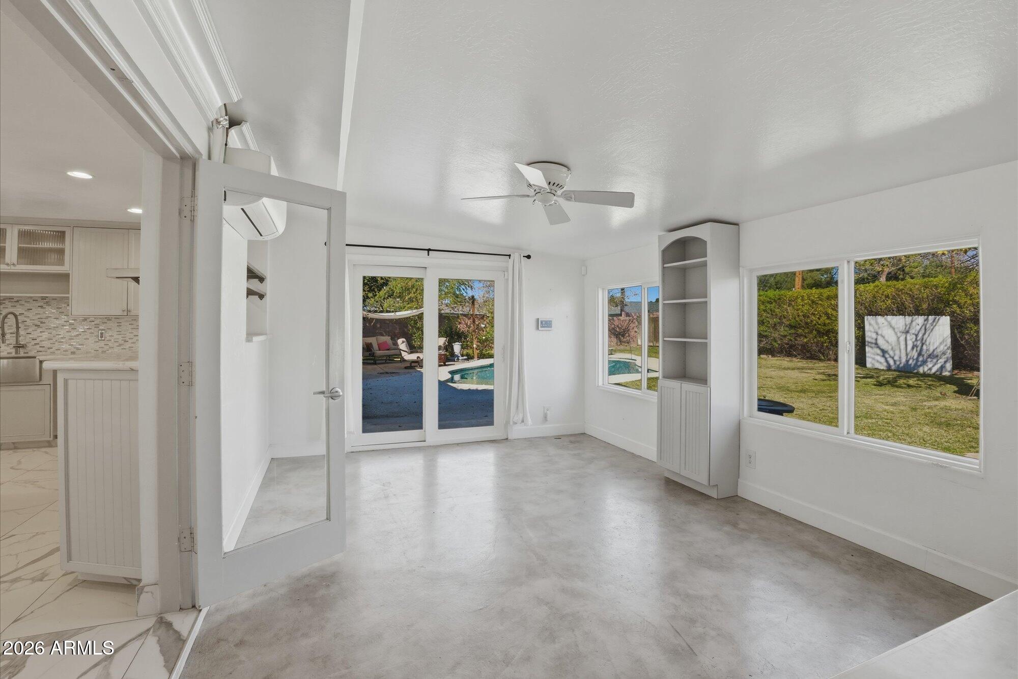 1532 West Loma Lane Phoenix, AZ 85021 - Photo 9 of 19 an empty room with large windows and wooden floor