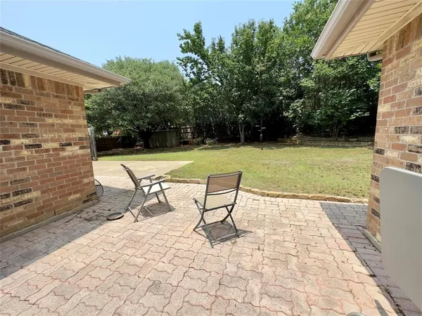 a view of a backyard with table and chairs under an umbrella