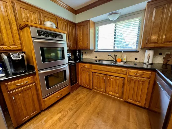 a kitchen with stainless steel appliances granite countertop a stove a sink and a microwave