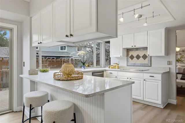 a kitchen with stainless steel appliances granite countertop a sink and white cabinets