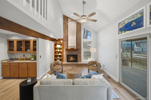 a living room with furniture a fireplace and a ceiling fan