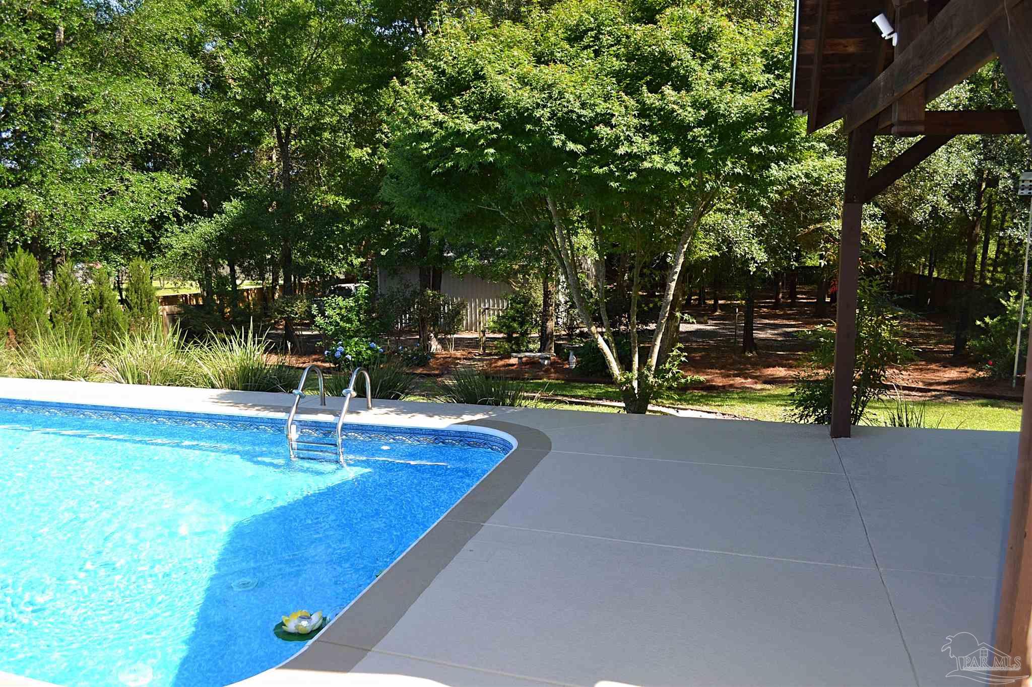 3055 Wallace Lake Road Pace, FL 32571 - Photo 5 of 33 a view of a swimming pool with an outdoor space and seating area