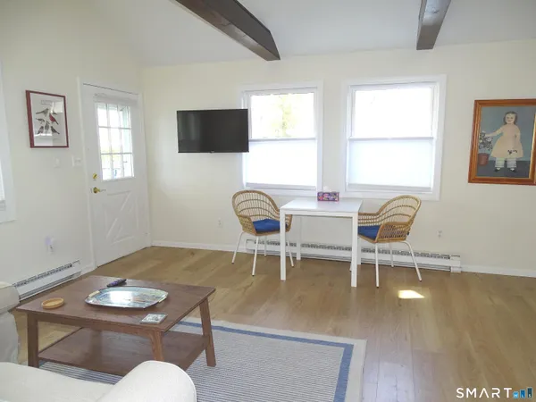 a living room with furniture a flat screen tv and windows